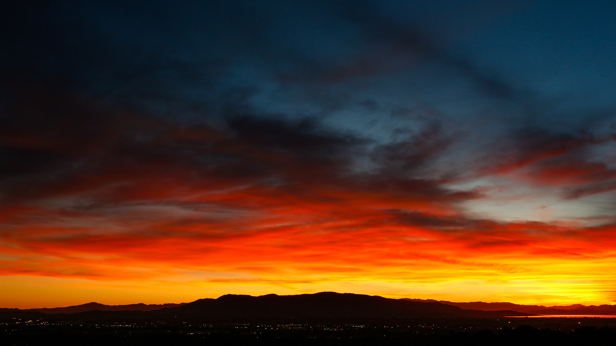 clouds lit unbelievably bright just above the west mountains yellow to orange to red